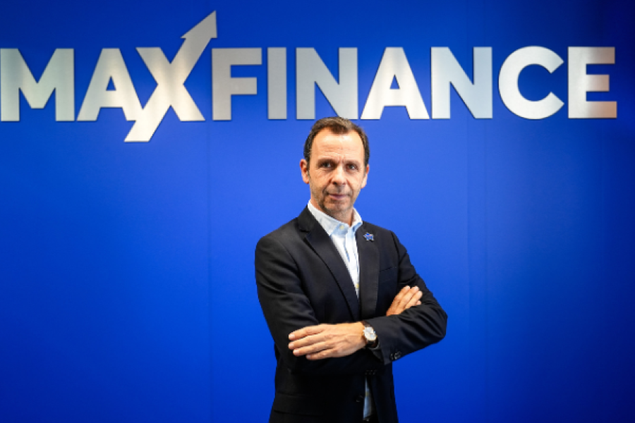 CEO Maxfinance de braços cruzados em fundo azul com logotipo